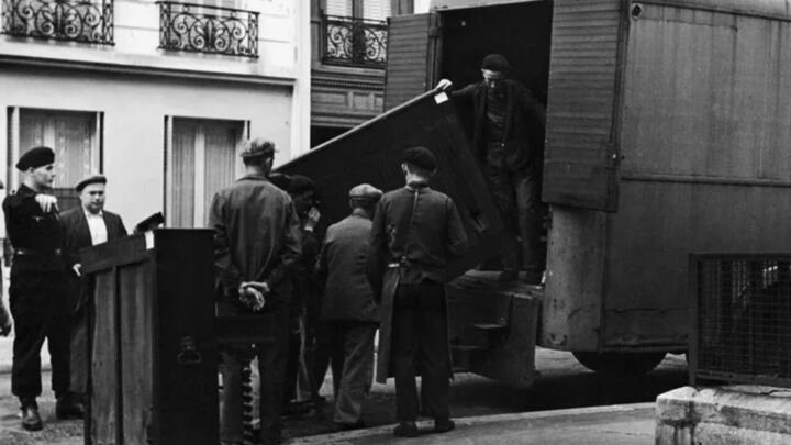 Internees from the Drancy camp unload pianos stolen from families of deportees at the Palais de Tokyo, Paris, 1943.